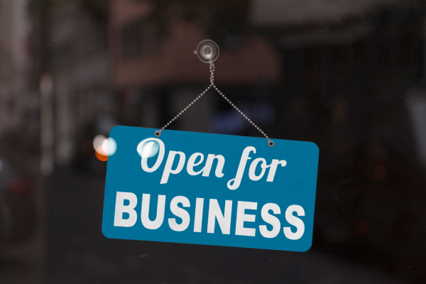 an "open for business" sign hanging in a store window.