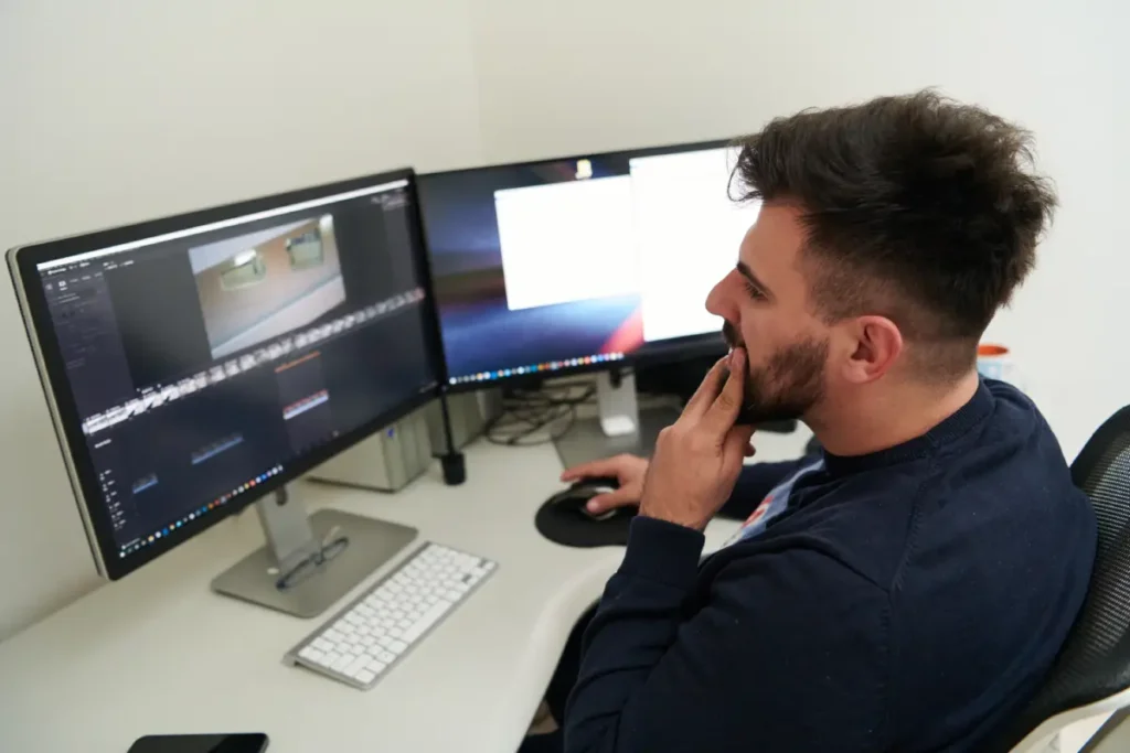 ad designer sitting in front of his computer editing videos.